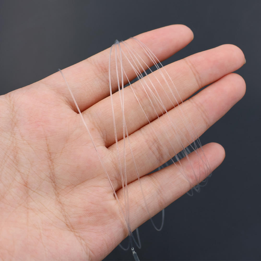 Clear tapered nylon fly fishing leader shown across a hand