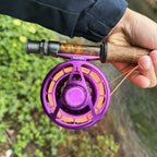 Side view of the purple Wifreo Alpha fly reel mounted on a fly rod outdoors